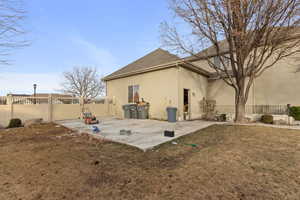 Rear view of property featuring a lawn and a patio