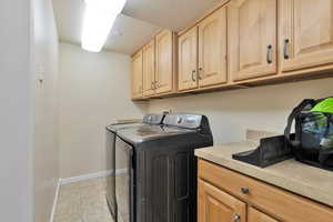 Laundry area featuring cabinets and separate washer and dryer