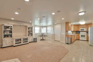 Kitchen featuring white appliances, decorative light fixtures, decorative backsplash, sink, and light tile patterned floors