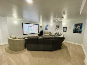 Home theater room featuring light carpet