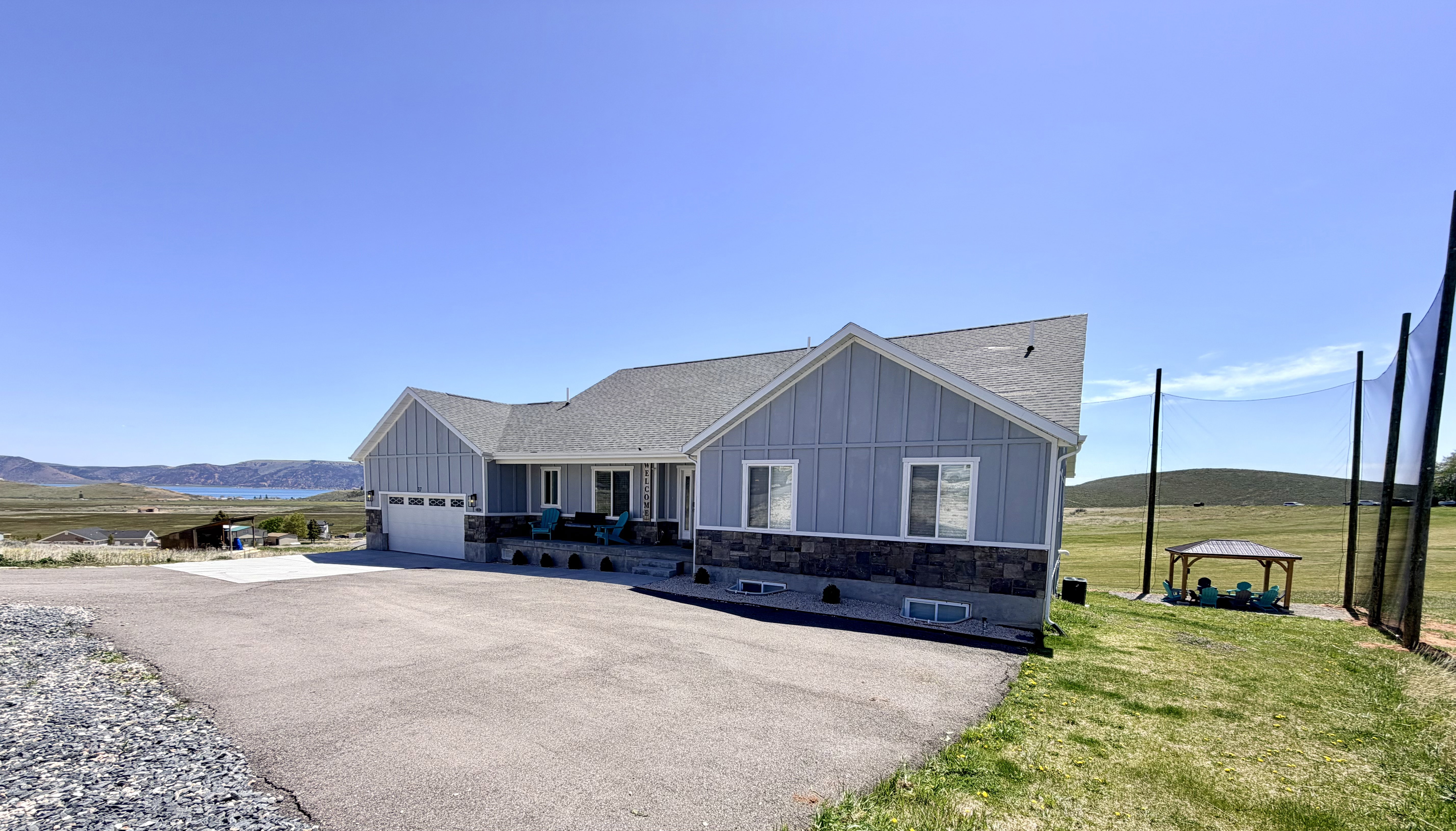 Ranch-style exterior featuring light blue vertical siding and a dark stone facade
