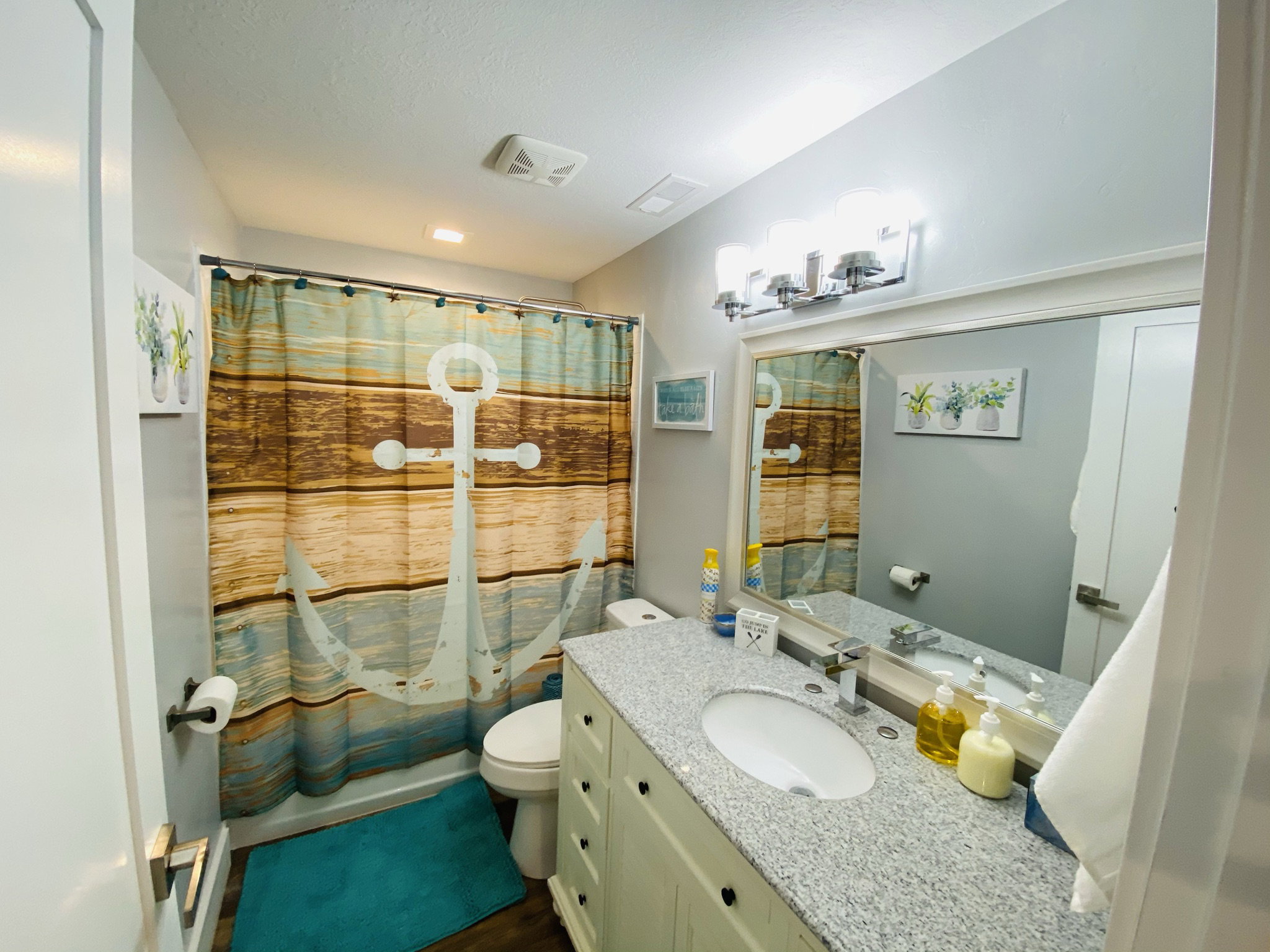 Full bathroom featuring toilet, vanity, and shower / bathtub combination with curtain
