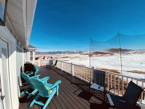 Snow covered deck with a mountain view