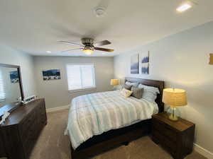 Carpeted bedroom featuring ceiling fan