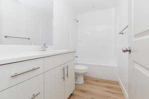 Full bathroom featuring bathtub / shower combination, hardwood / wood-style floors, toilet, and vanity