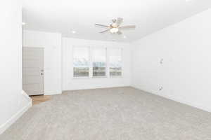 Carpeted spare room featuring ceiling fan