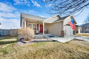 View of front of property with a garage, a front yard, and a porch