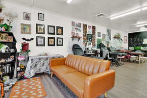 Living room featuring ornamental molding, a textured ceiling, and hardwood / wood-style floors