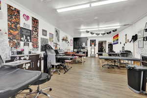 Home office featuring rail lighting, a textured ceiling, light hardwood / wood-style flooring, and crown molding