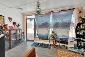 Living area featuring a textured ceiling, ornamental molding, and hardwood / wood-style floors