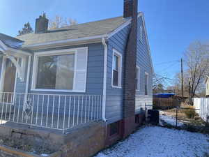 Snow covered property with central air condition unit