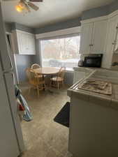 Kitchen with ceiling fan, sink, and white cabinets