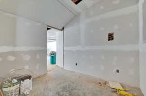 Empty room featuring vaulted ceiling