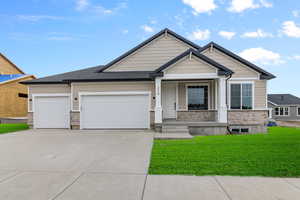 Craftsman inspired home featuring a garage and a front lawn