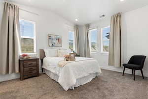 Carpeted primary bedroom with vaulted ceiling