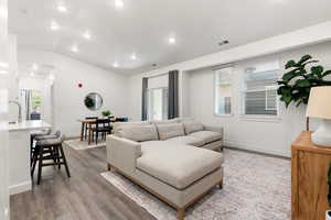 Living room, wood-type flooring, and lofted ceiling