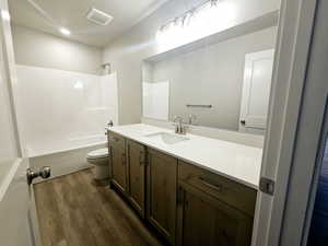 Full bathroom with toilet, hardwood / wood-style flooring, vanity, and shower / bathing tub combination