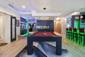 Rec room featuring ornamental molding, hardwood / wood-style floors, bar area, and billiards