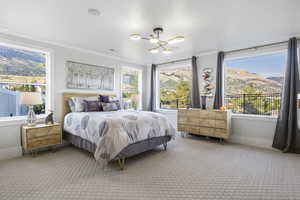 Bedroom featuring carpet floors, crown molding, a mountain view, and a chandelier