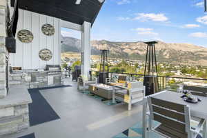 View of patio / terrace with an outdoor kitchen, an outdoor living space with a fire pit, a mountain view, and area for grilling