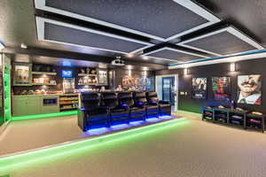 Carpeted cinema with indoor bar and coffered ceiling