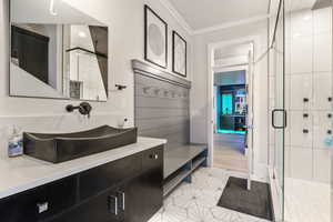 Bathroom featuring walk in shower, vanity, tile patterned floors, and crown molding