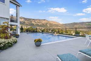 View of pool with a mountain view and a patio