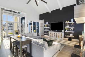 Living room with ceiling fan, beamed ceiling, light hardwood / wood-style flooring, and high vaulted ceiling