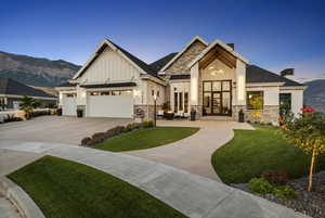 View of front of home featuring a mountain view, a yard, and a garage