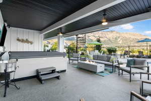 View of patio / terrace featuring an outdoor living space with a fire pit, a mountain view, and a hot tub