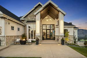 Exterior entry at dusk featuring a patio area