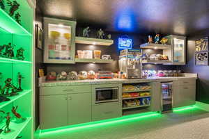 Recreation room featuring a textured ceiling, wine cooler, and bar area