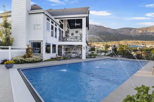 View of pool with pool water feature, ceiling fan, a mountain view, and a patio