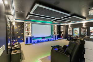 Cinema room featuring a textured ceiling and carpet