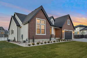 View of front of house featuring central AC unit and a yard