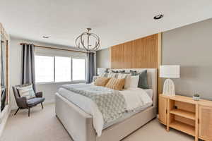 Bedroom featuring an inviting chandelier and light colored carpet