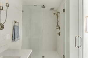 Bathroom featuring an enclosed shower and vanity