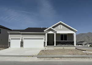 View of front of ACTUAL house featuring a 3 car garage, concrete driveway, covered porch, and a mountain view. Home will have front yard landscaping installed.