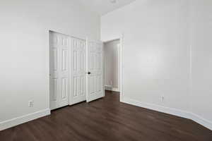 Unfurnished bedroom with a closet and dark hardwood / wood-style floors