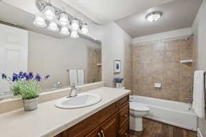 Full bathroom featuring toilet, vanity, hardwood / wood-style flooring, and tiled shower / bath