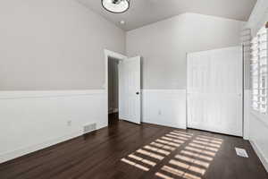 Unfurnished bedroom featuring a closet and dark wood-type flooring