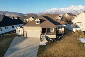 View of front of house featuring covered porch, a front lawn, a garage, and a mountain view