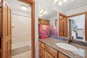 Full bathroom featuring tile patterned floors, vanity, toilet, and shower / tub combo with curtain