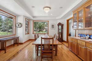 Dining space featuring a raised ceiling and light hardwood / wood-style floors