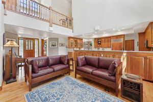 Living room featuring a high ceiling, a wealth of natural light, and light hardwood / wood-style flooring