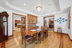 Dining space featuring light hardwood / wood-style flooring and a tray ceiling