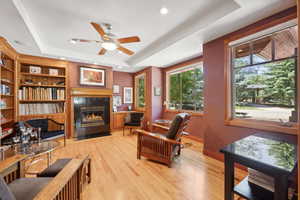 Interior space featuring ceiling fan, hardwood / wood-style floors, built in shelves, and a raised ceiling