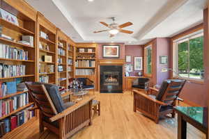 Sitting room featuring ceiling fan, light hardwood / wood-style flooring, and a raised ceiling