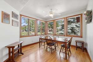 Dining area with ceiling fan and light hardwood / wood-style flooring