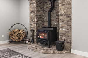 Details with a wood stove and hardwood / wood-style flooring